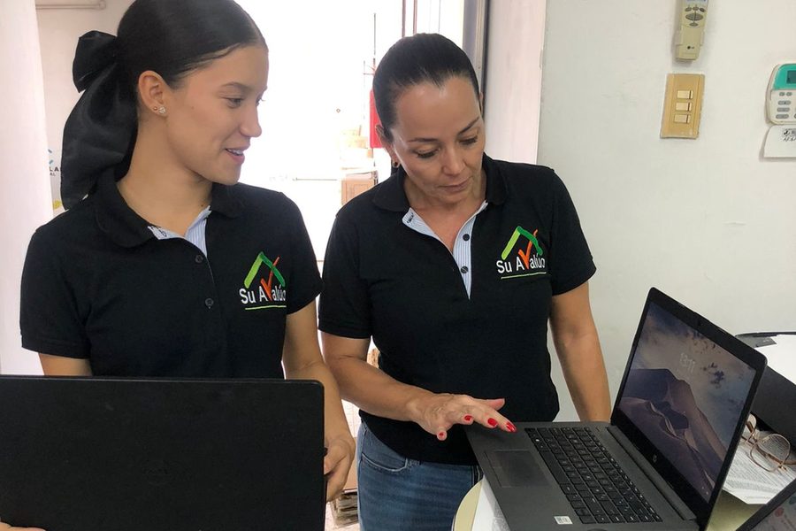 Analistas de Suavalúo revisando información financiera en el computador